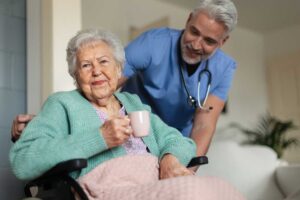 Older adults share a calm breakfast while a caregiver reviews a daily schedule nearby.